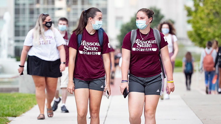Two Missouri State students talking as they walk to class. 