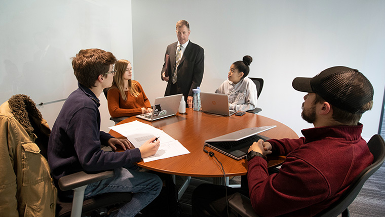 Students work on their management and human resources projects with Dr. Wes Scroggings.
