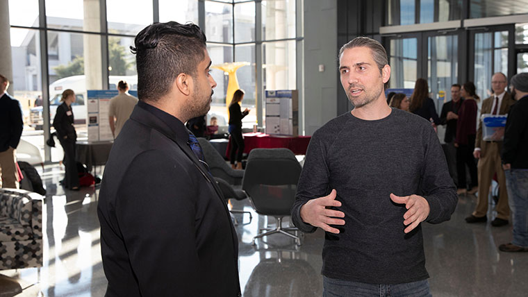 Student talking to businessman in Glass Hall
